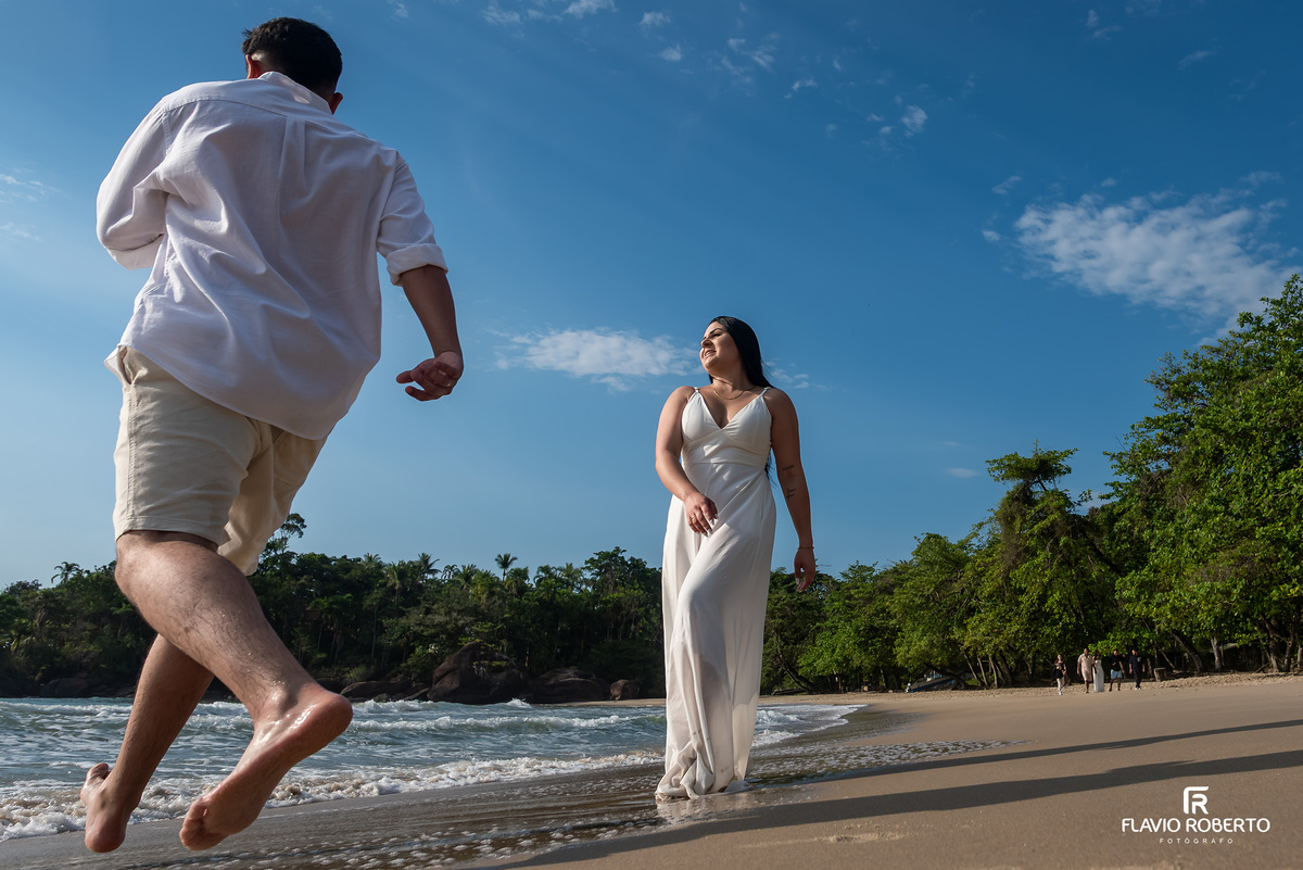 Ensaio pré wedding na praia de Ubatuba ao nascer do sol com casal em movimento, fotografia espontânea e cheia de vida