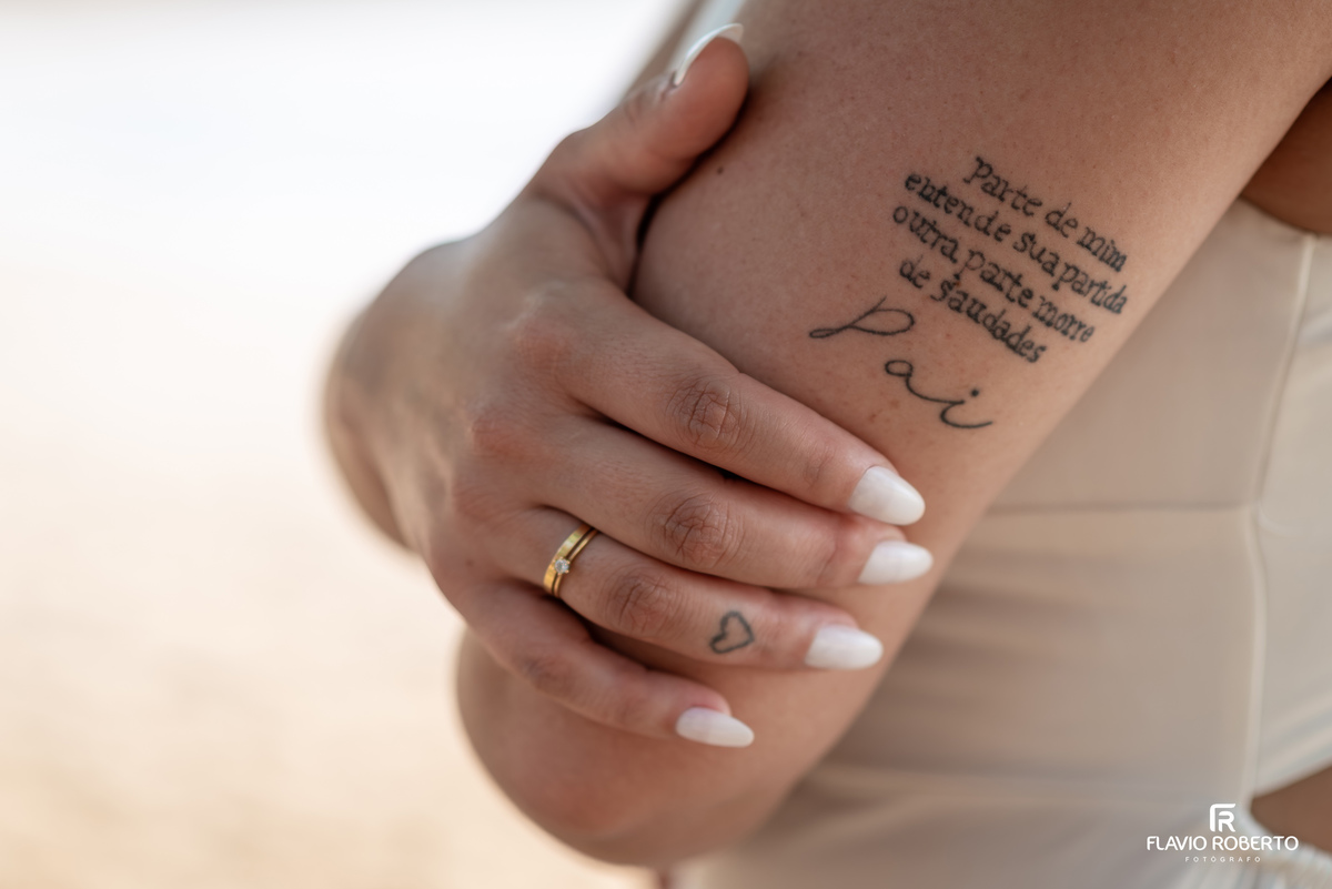 Detalhe de ensaio pré casamento na praia de Ubatuba com tatuagem e aliança, fotografia sensível e cheia de significado