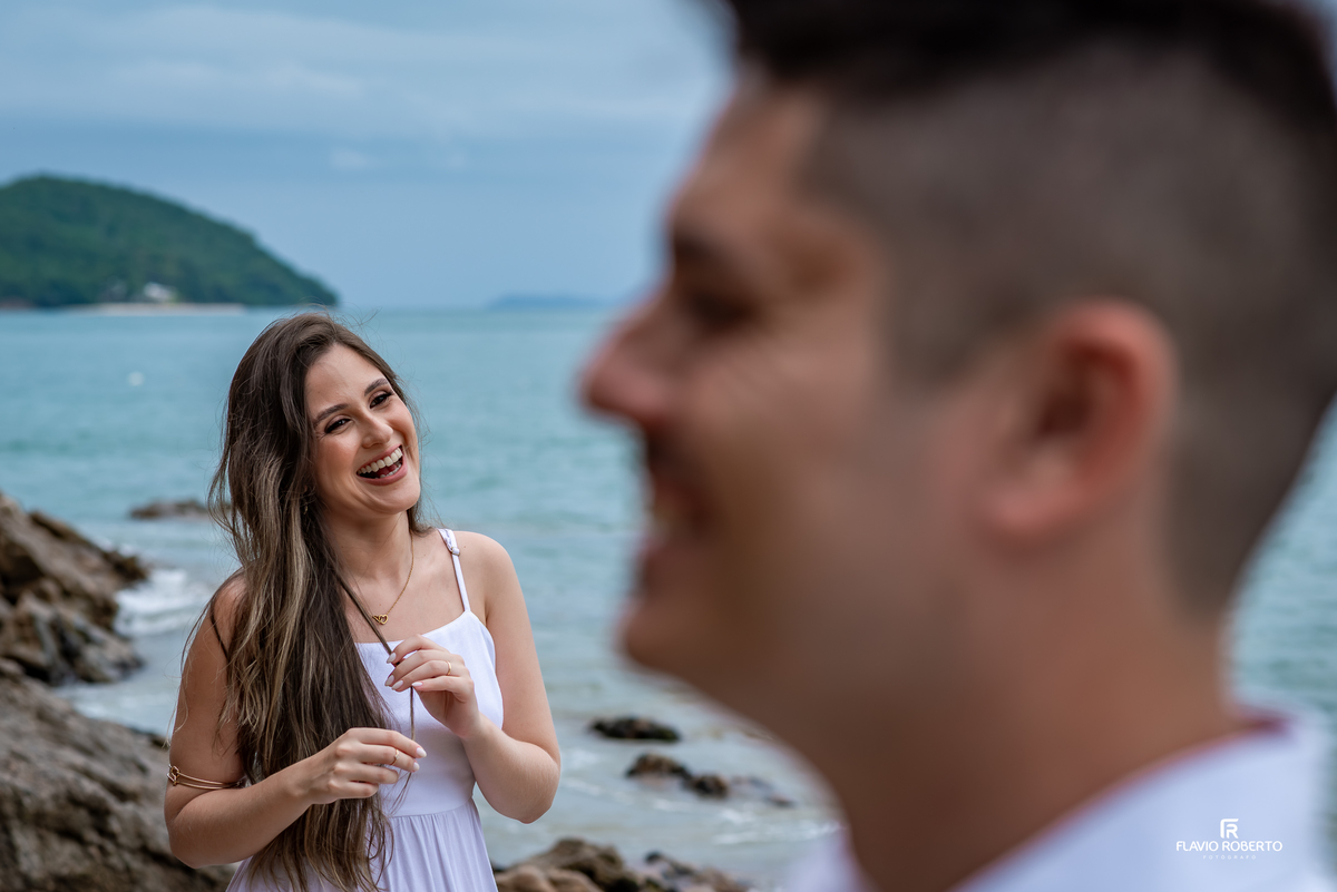 Ensaio pre wedding na Praia da Almada Ubatuba com casal sorrindo e interagindo à beira-mar, fotografia emocional e natural