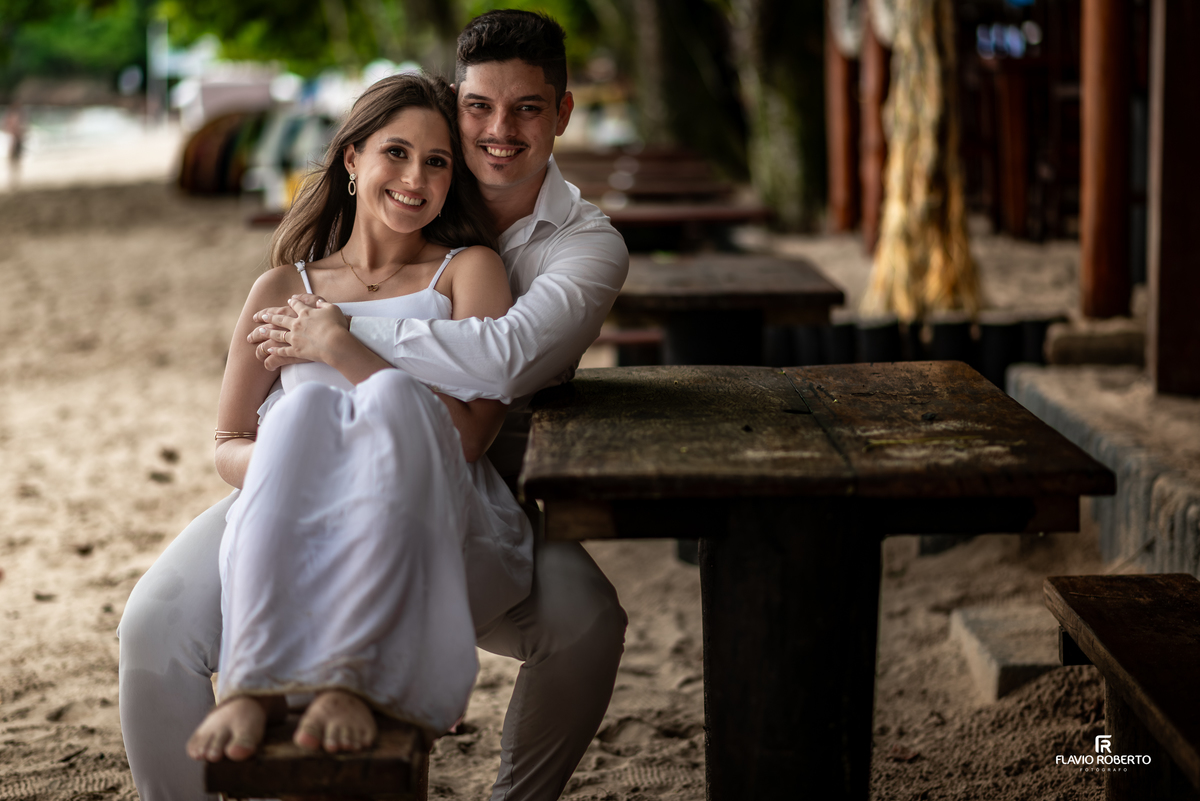 Ensaio pre wedding na praia em Ubatuba com casal sentado em quiosque, conexão verdadeira e fotos naturais no litoral paulista