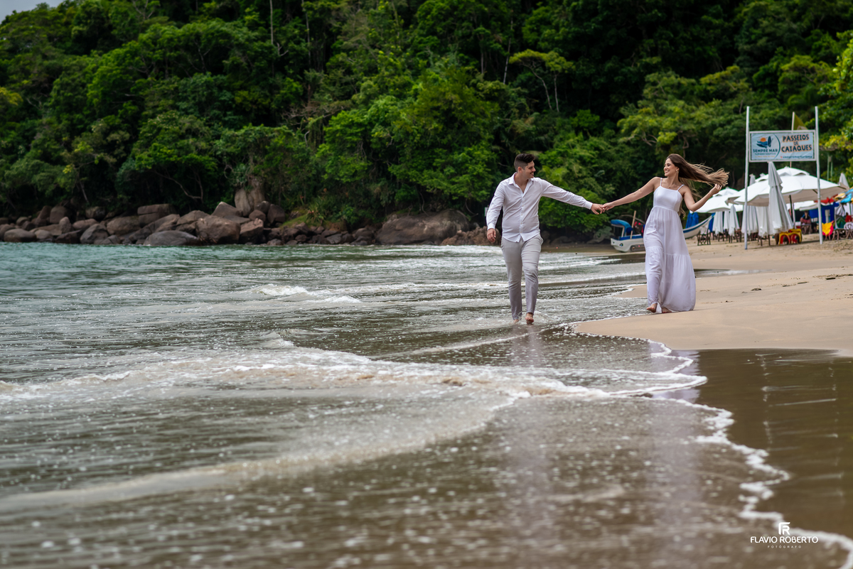 Ensaio pré casamento na Praia da Almada Ubatuba com casal caminhando pela orla, fotografia natural e espontânea no litoral paulista