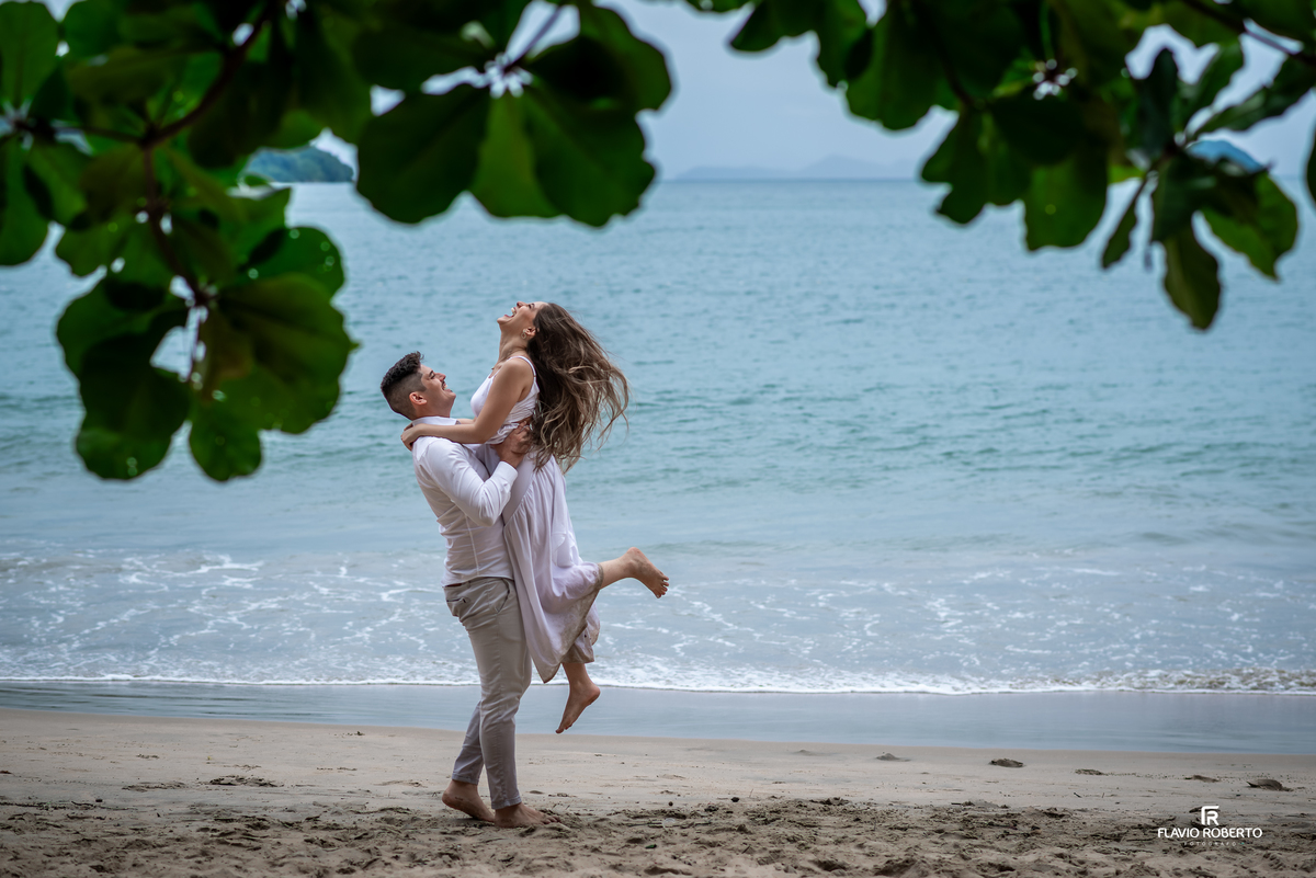 Ensaio pré casamento na Praia da Almada em Ubatuba com casal celebrando o amor à beira-mar, fotografia leve e cheia de emoção