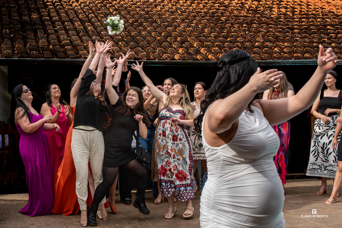 Noiva jogando o buquê na recepção do casamento em sítio em Campos Novos