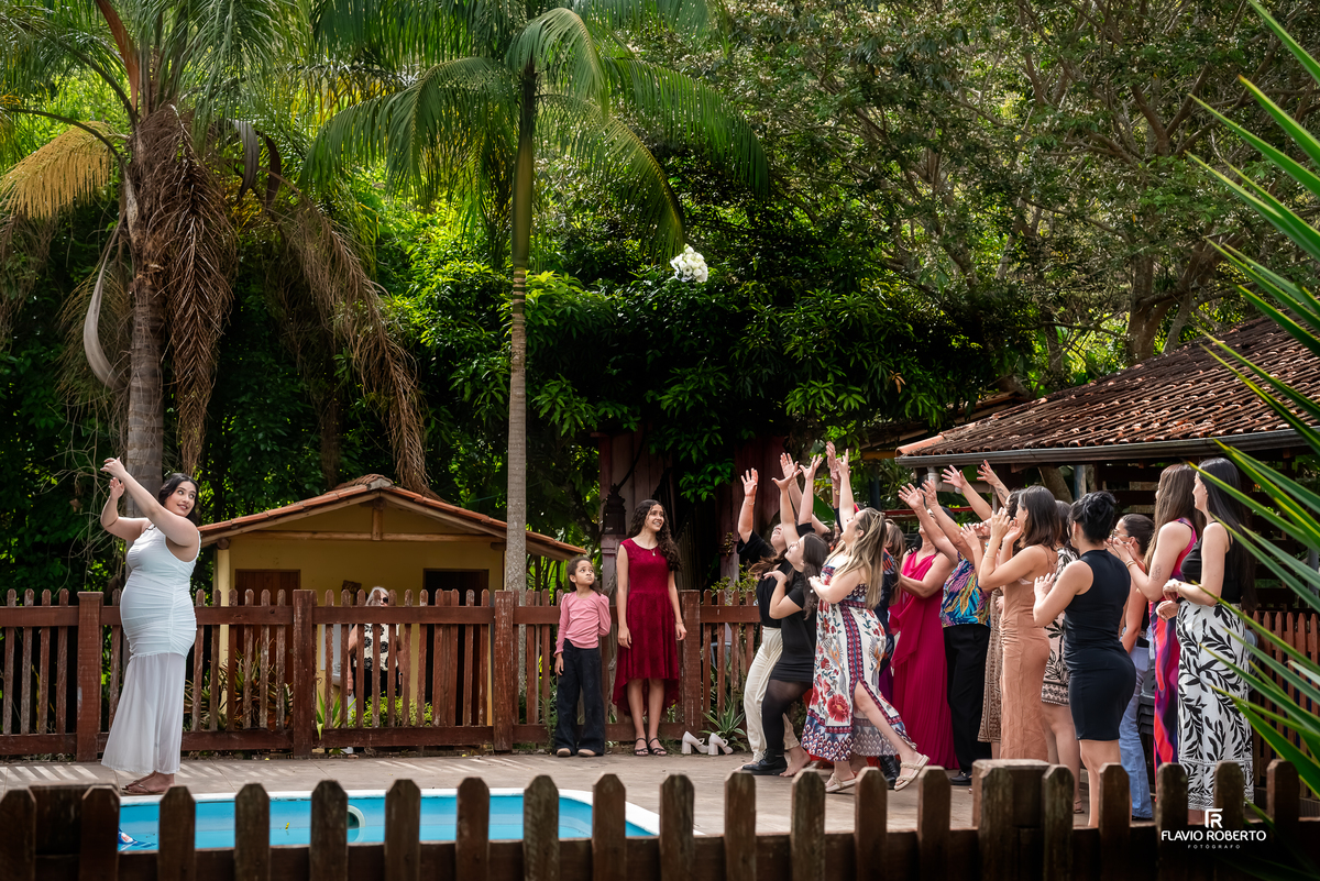 Noiva jogando o buquê na recepção do casamento em sítio em Campos Novos