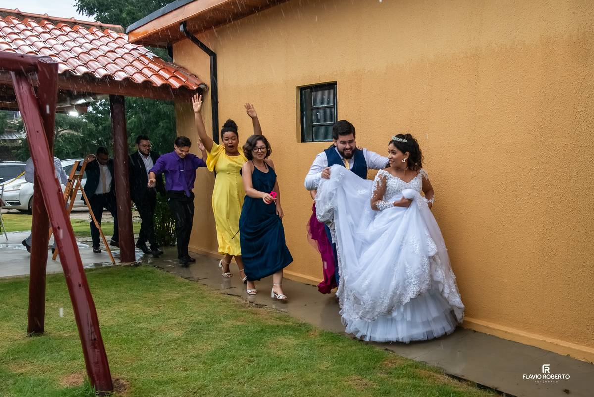 noivos celebrando na chuva durante a festa de casamento na Chácara Recanto da Lagoa em Canas
