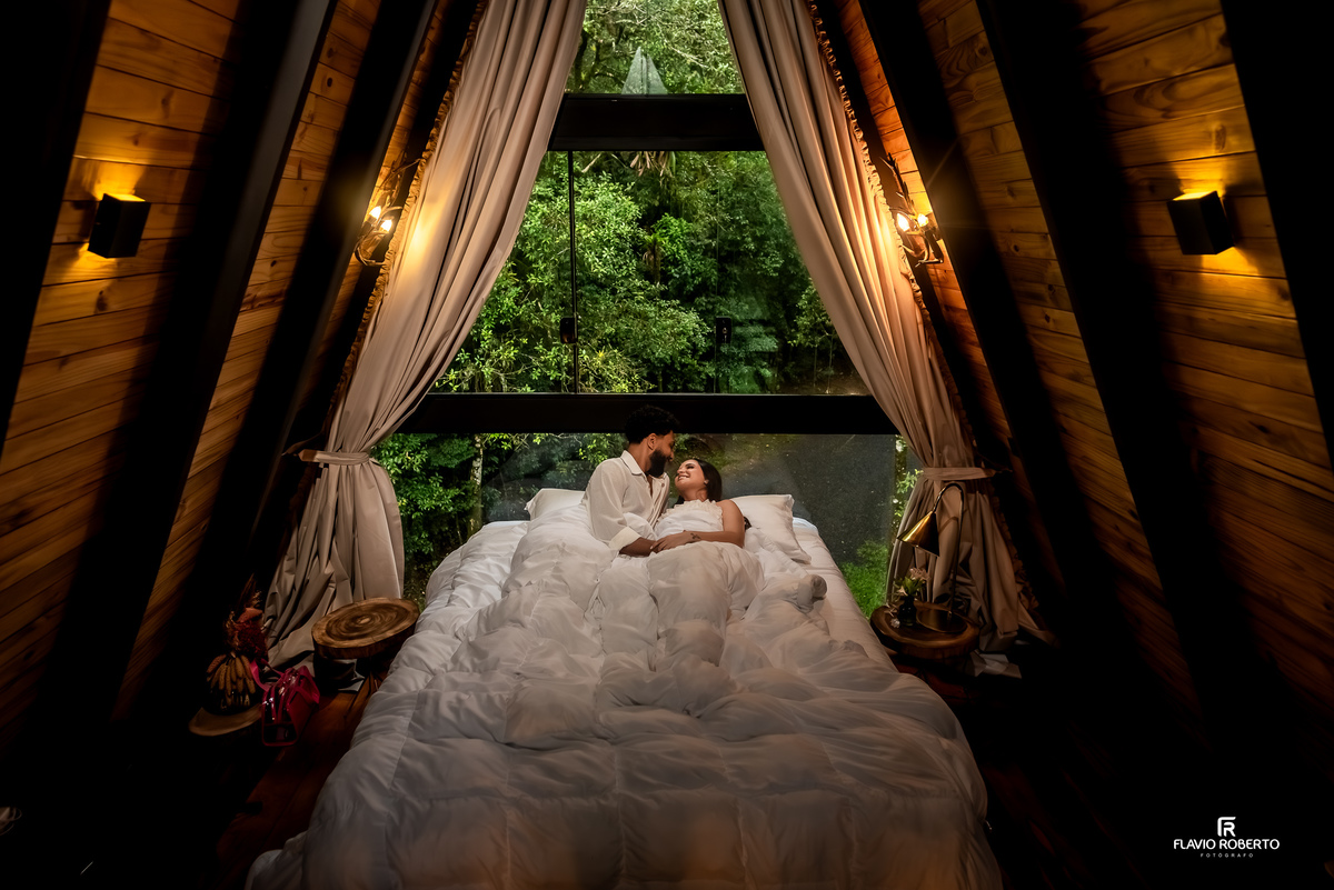 casal deitado na cama durante ensaio pre wedding em cabana na Lake View Cabanas em São Francisco Xavier