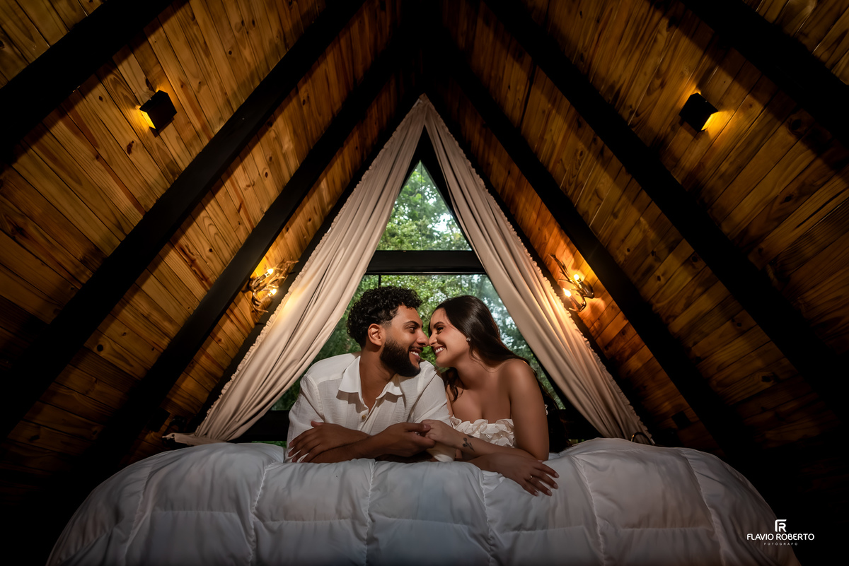 casal deitado na cama durante ensaio pre wedding em cabana na Lake View Cabanas em São Francisco Xavier