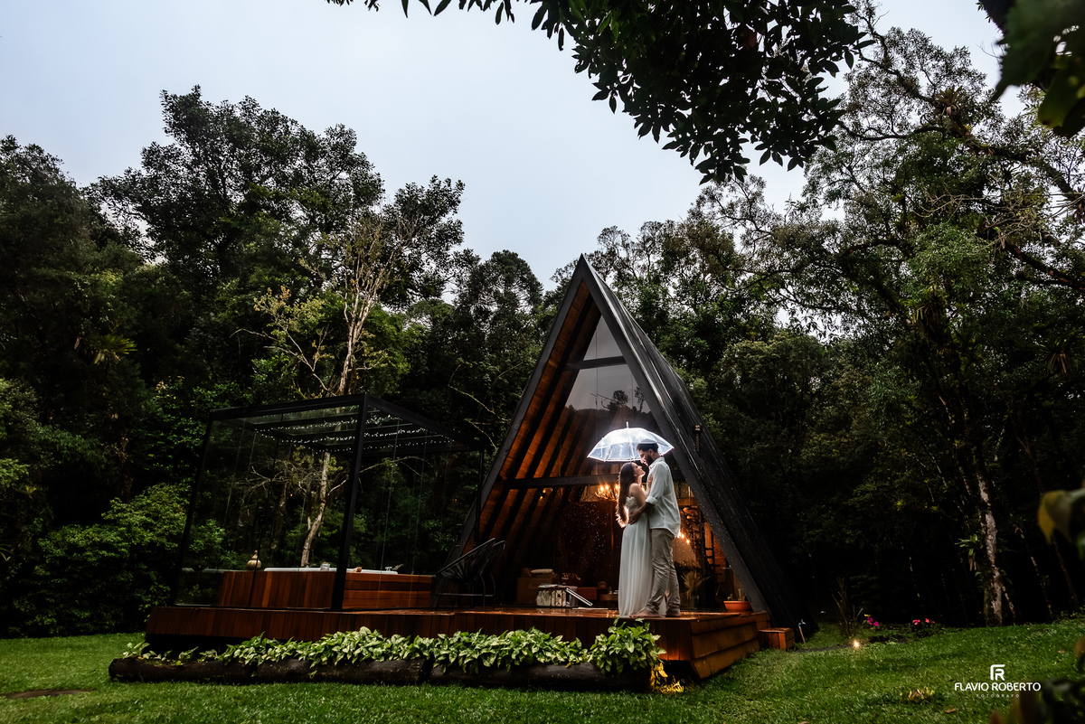 ensaio pre wedding do casal em frente à cabana na chuva na Lake View Cabanas em São Francisco Xavier