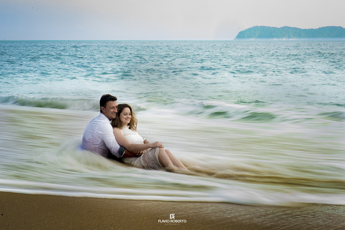 Noivos no véu das ondas do mar durante Ensaio Pre Wedding em Ubatuba
