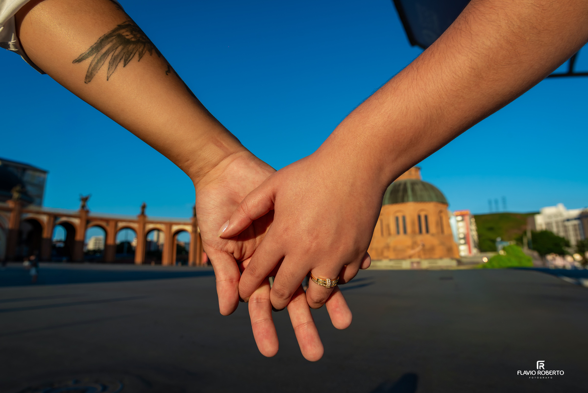 Detalhe das mãos do casal entrelaçadas durante ensaio pré wedding no Santuário Nacional de Aparecida