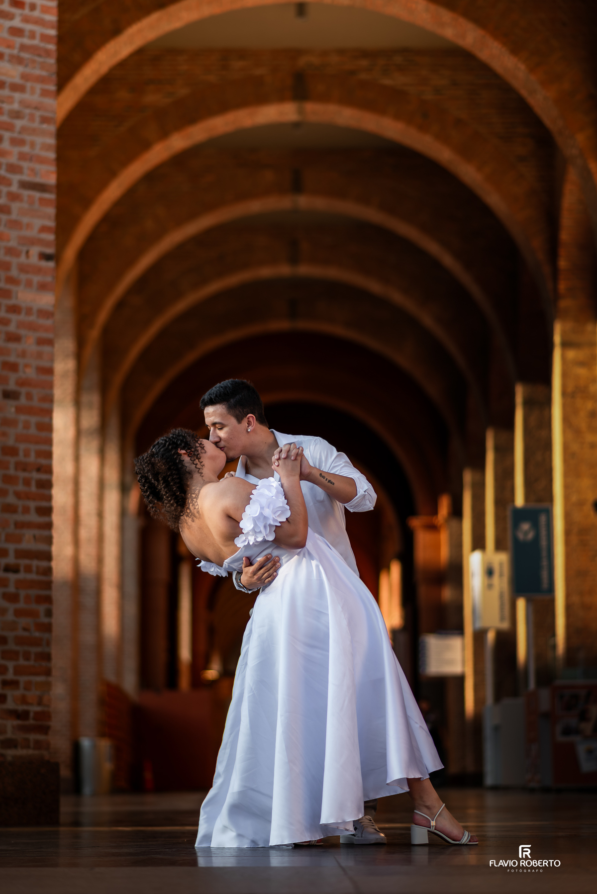 Casal em ensaio pré wedding no Santuário de Aparecida em momento romântico sob os arcos da arquitetura