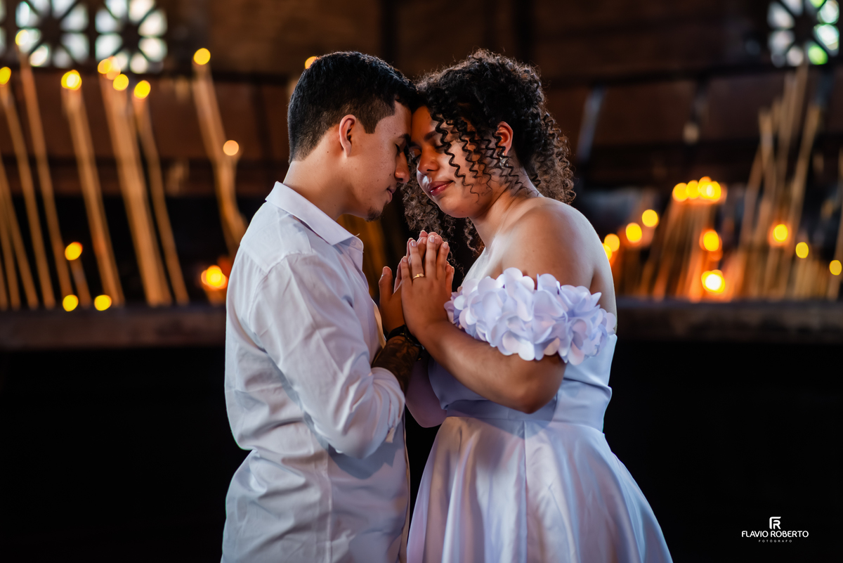 Close do casal em ensaio pré wedding no Santuário de Aparecida com luz suave ao fundo e conexão íntima
