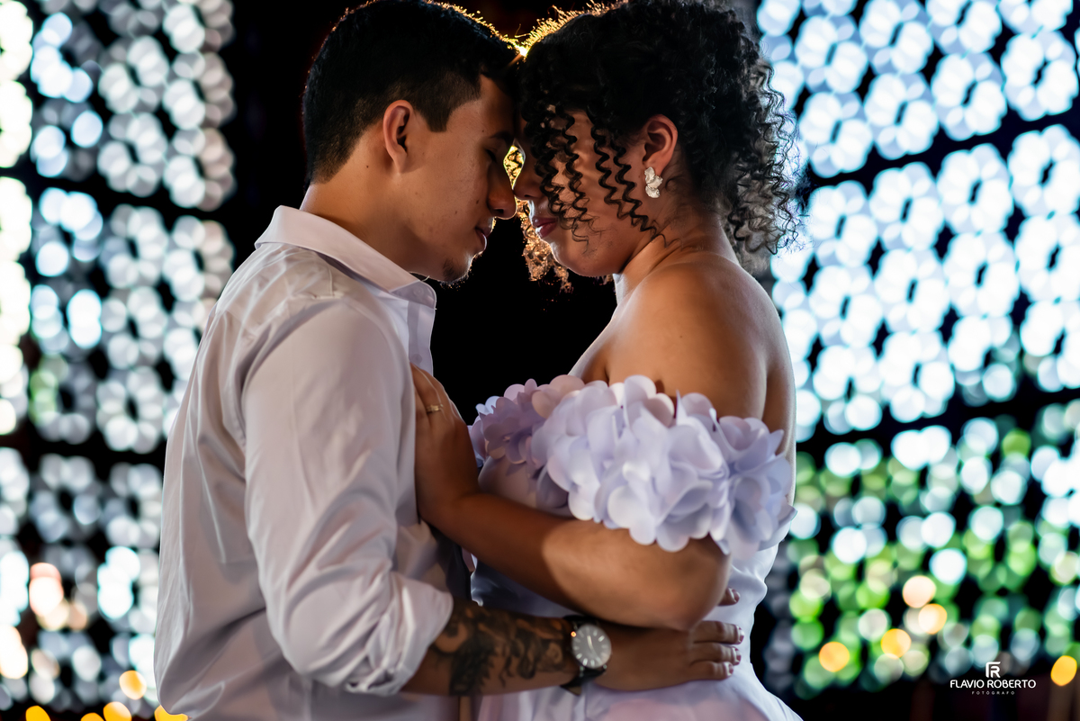 Close do casal em ensaio pré wedding no Santuário de Aparecida com luz suave ao fundo e conexão íntima