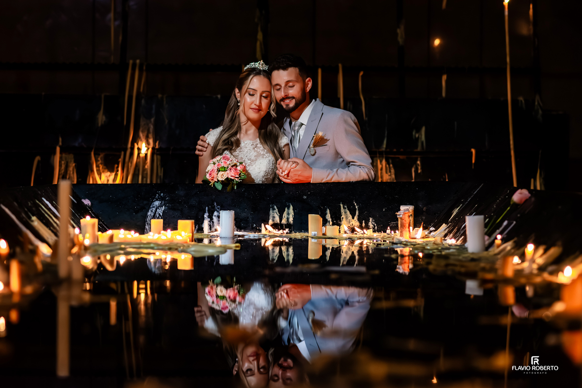 Noivos em momento de oração com velas durante casamento no Santuário de Aparecida