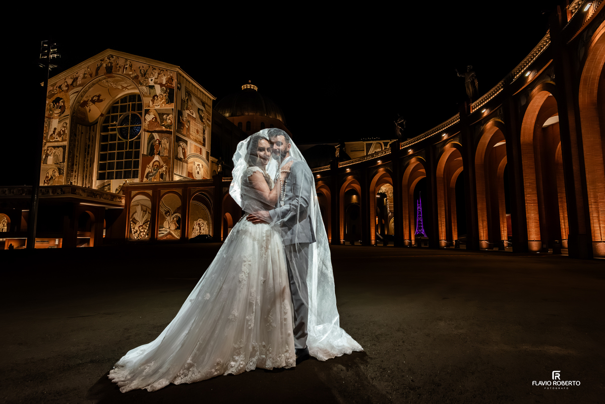 Noivos sob o véu em ensaio noturno no Santuário Nacional de Aparecida