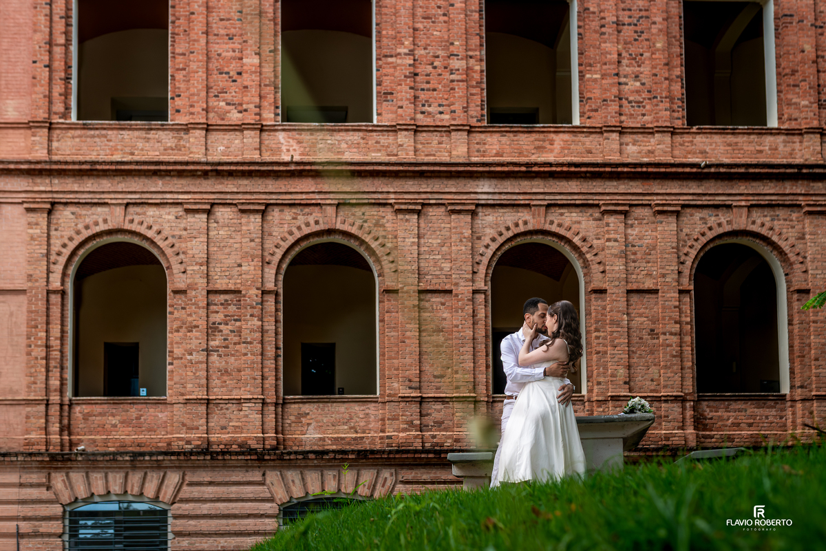 Casal se abraçando em frente à arquitetura da Pousada Bom Jesus em Aparecida durante ensaio pré wedding no Vale do Paraíba
