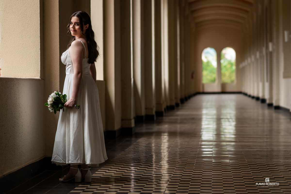 Noiva posicionada em corredor com arcos na Pousada Bom Jesus em Aparecida com luz suave