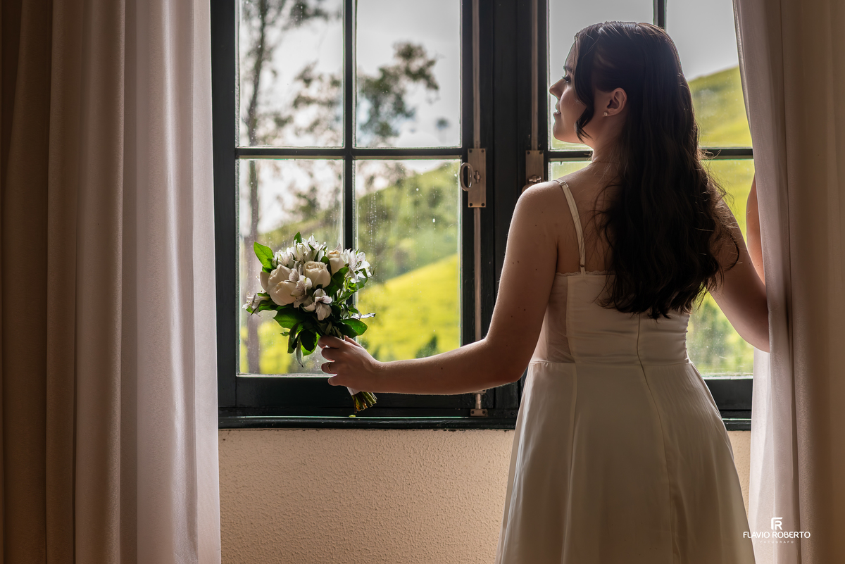 Noiva posicionada em corredor com arcos na Pousada Bom Jesus em Aparecida com luz suave