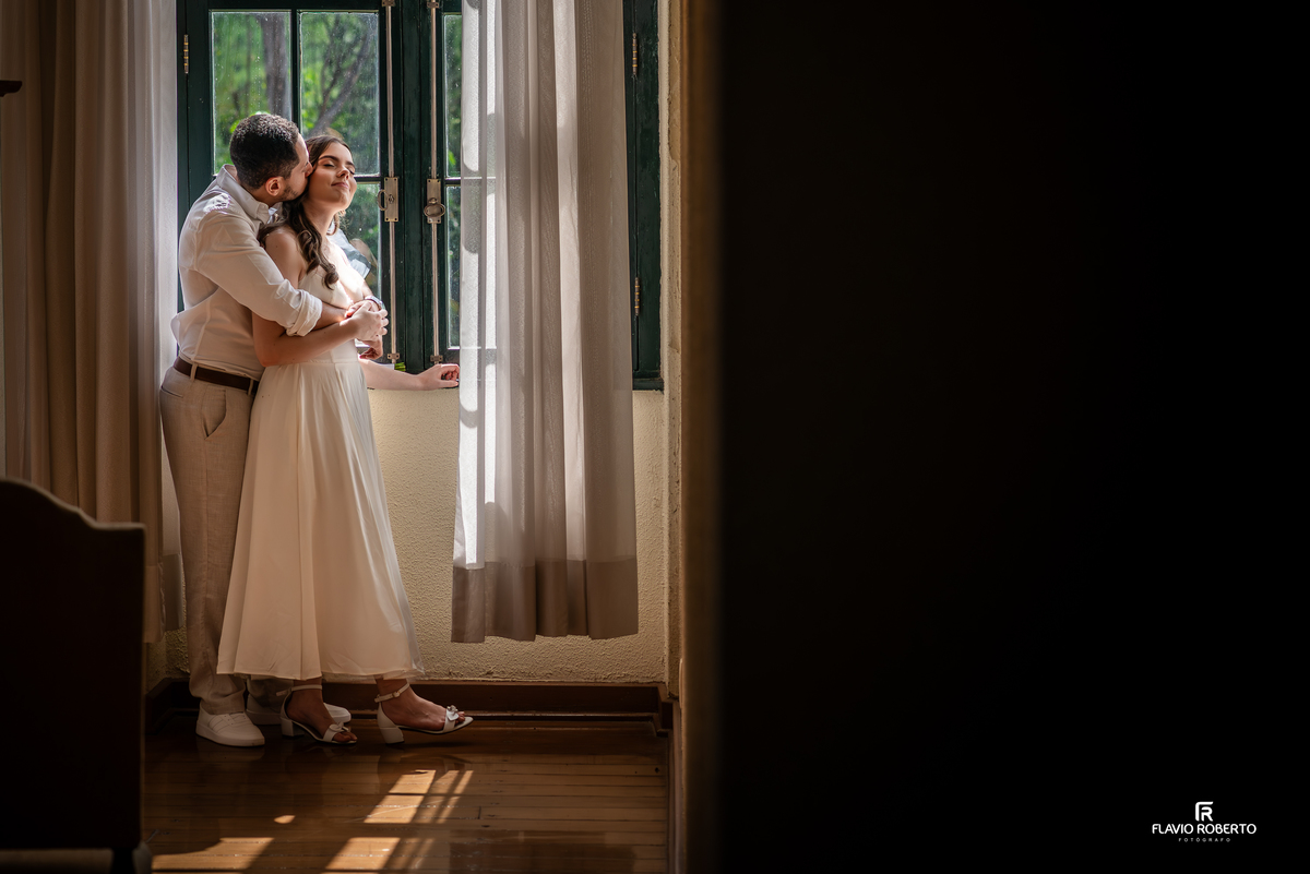 Casal em momento romântico com luz natural no Seminário Bom Jesus em Aparecida