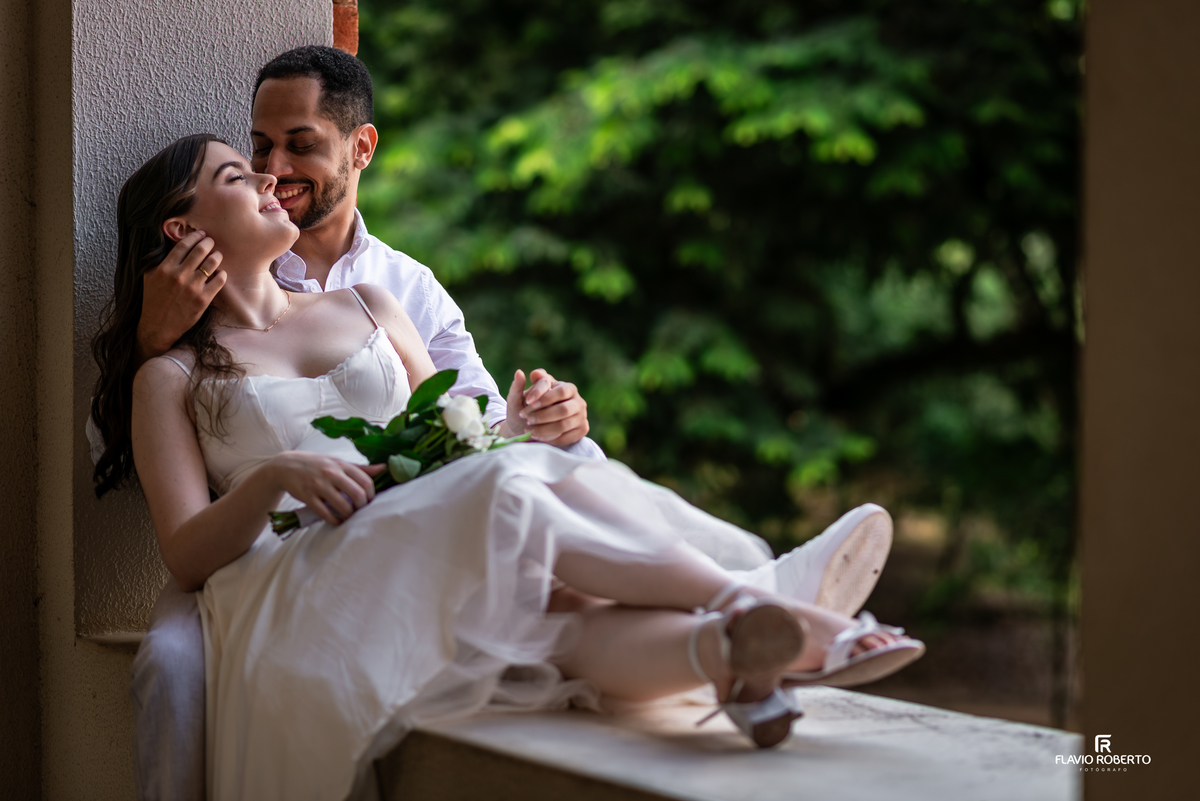 Casal em ensaio pré wedding próximo à janela com luz natural no Seminário Bom Jesus em Aparecida