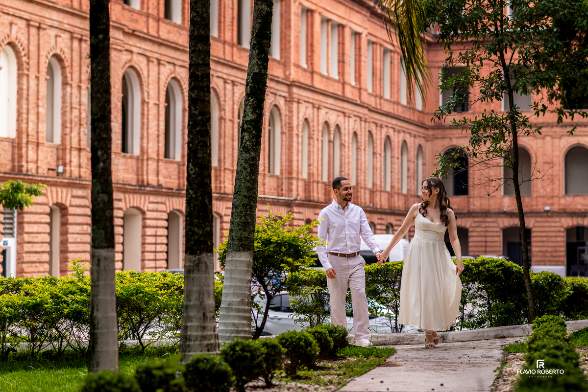 Casal caminhando entre árvores na Pousada Bom Jesus em Aparecida durante ensaio pré wedding