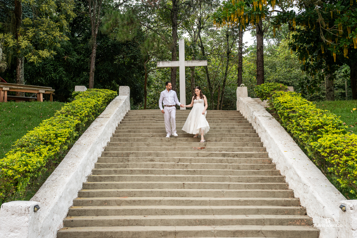 Casal descendo escadaria na Pousada Bom Jesus em Aparecida com natureza ao redor no Vale do Paraíba