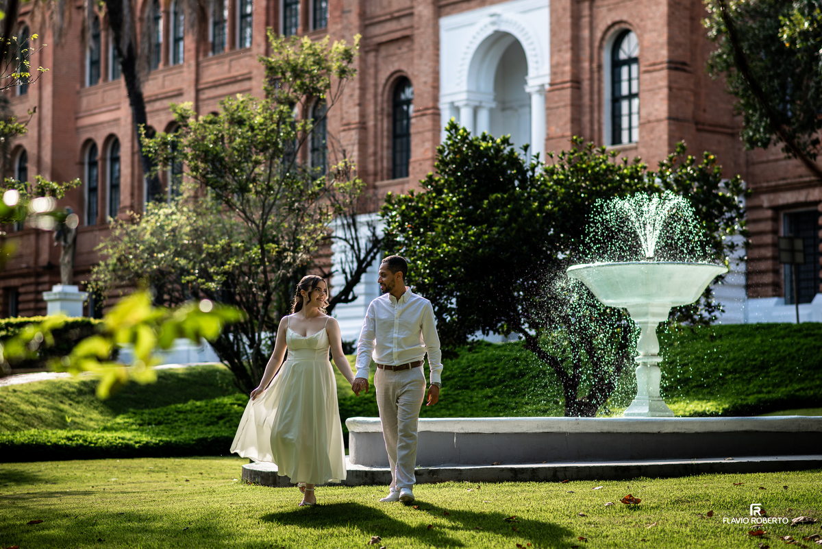 Casal caminhando próximo à fonte na Pousada Bom Jesus em Aparecida com composição natural e leve