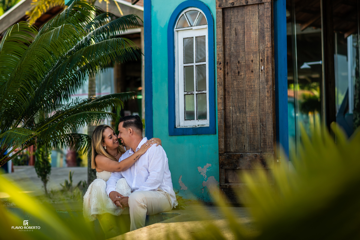 Casal sentado próximo à capela durante ensaio fotográfico