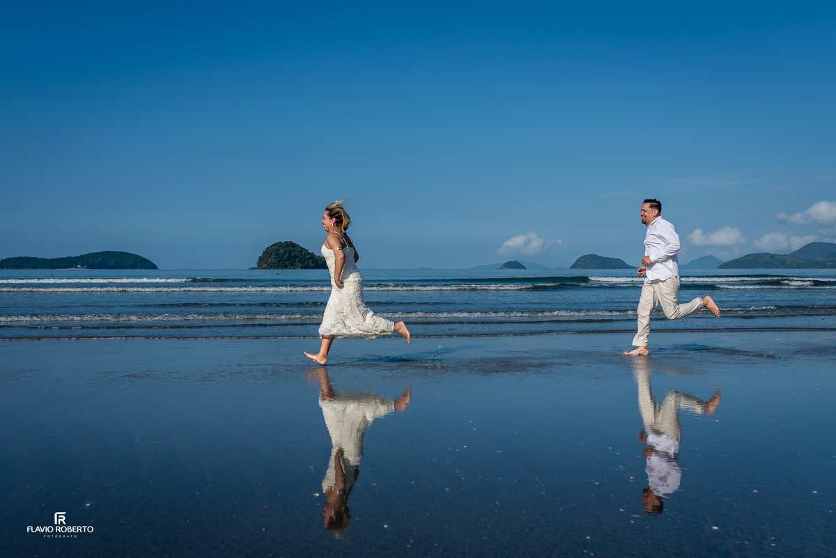 Casal correndo na praia em Ubatuba durante ensaio de casal