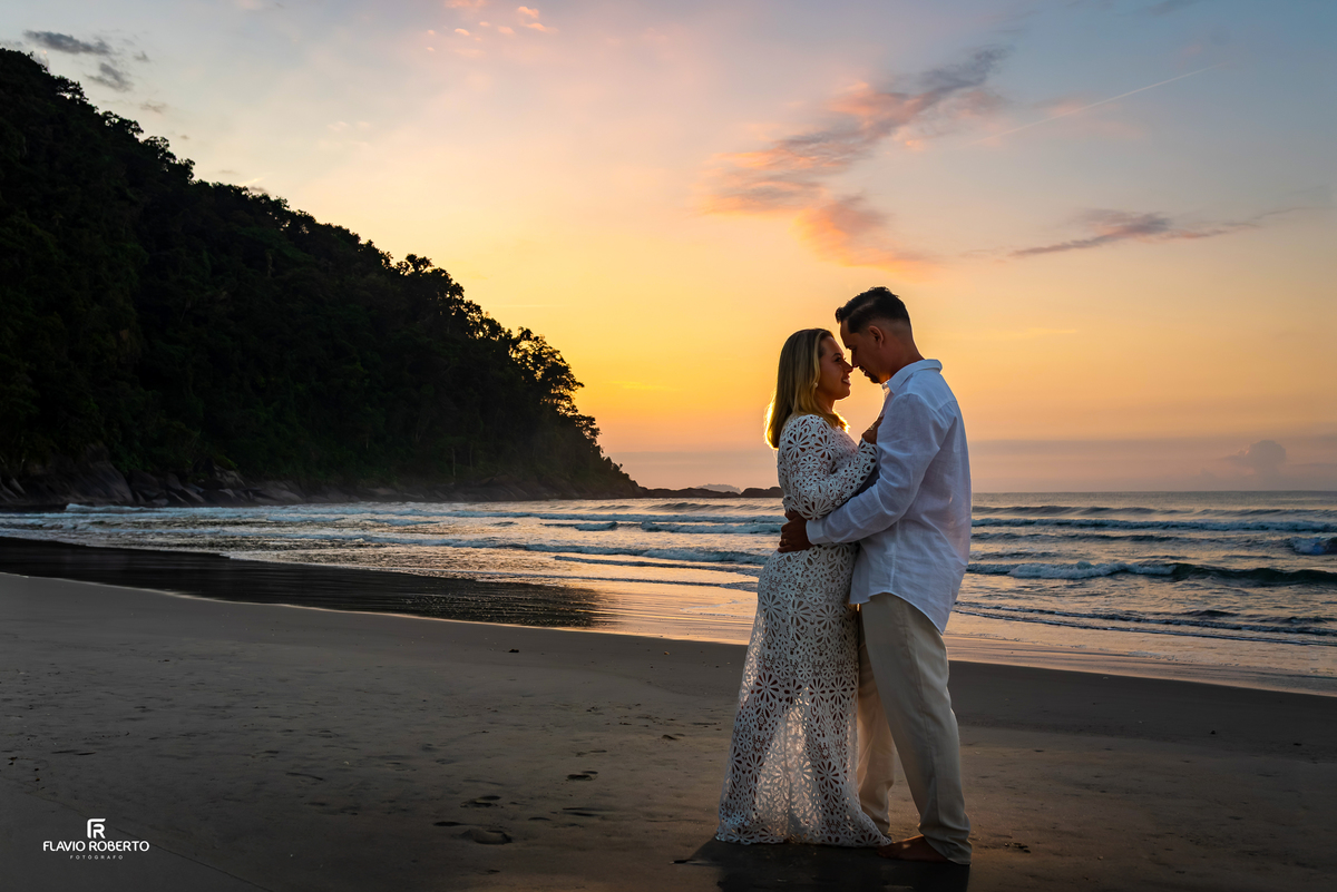 Casal celebrando 10 anos de casamento ao pôr do sol em Itamambuca Ubatuba