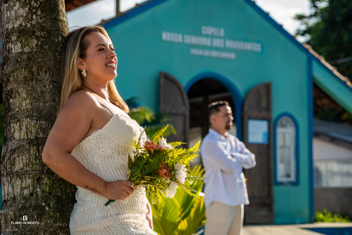 Noiva durante ensaio na praia em frente à capela em Ubatumirim