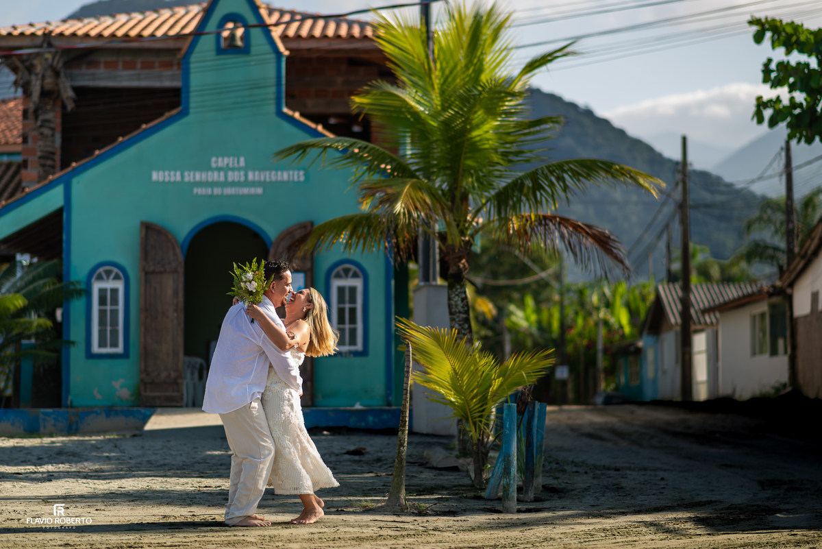 Casal abraçado em frente à capela durante ensaio em Ubatuba
