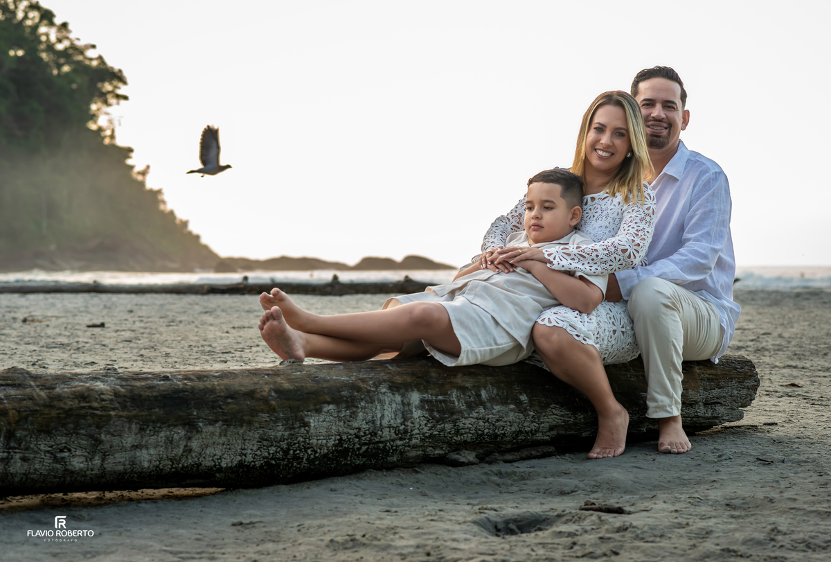 Família sentada
 na praia em ensaio fotográfico espontâneo