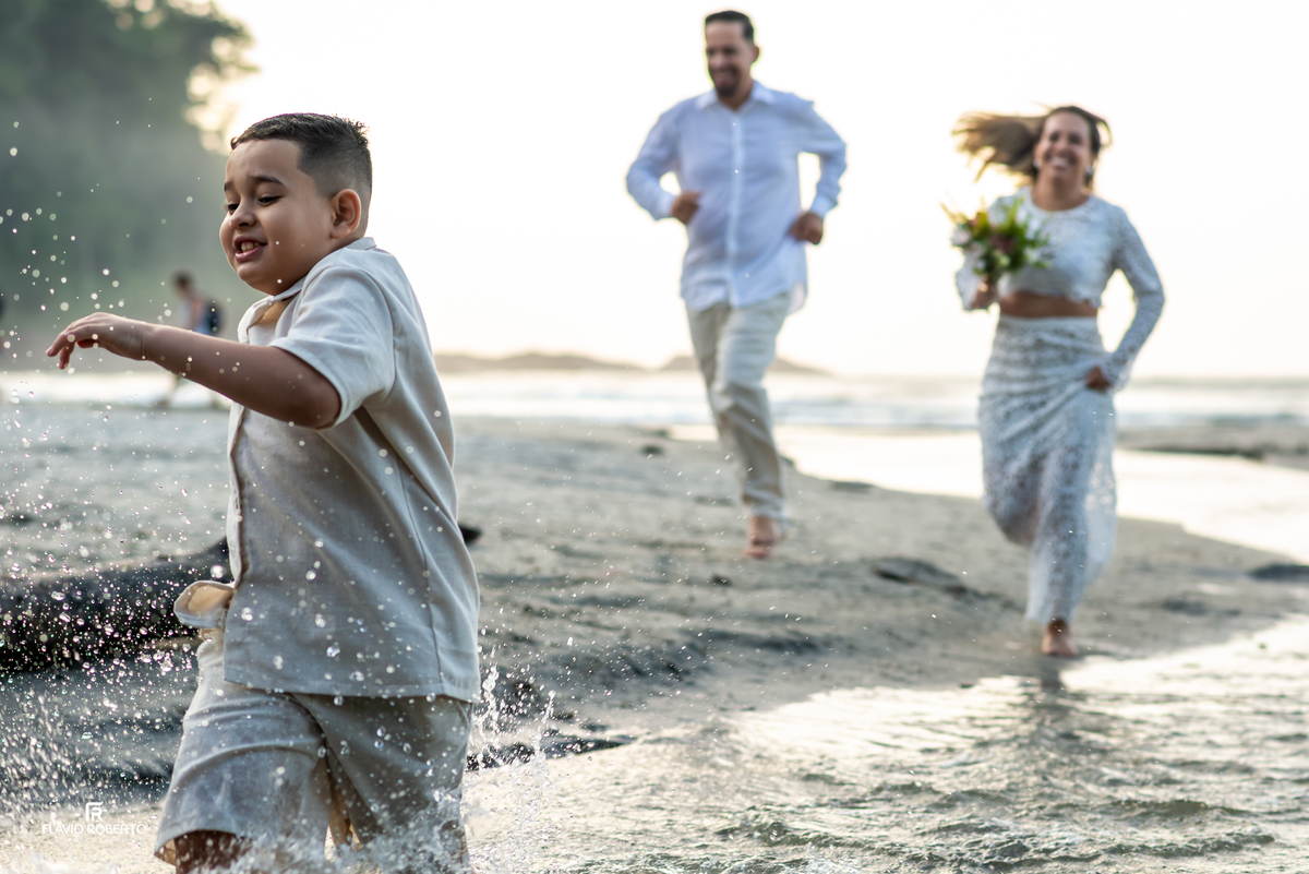 Família correndo na praia durante ensaio de 10 anos de casamento