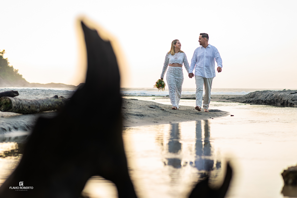 Casal caminhando na Praia do Ubatumirim durante ensaio fotográfico