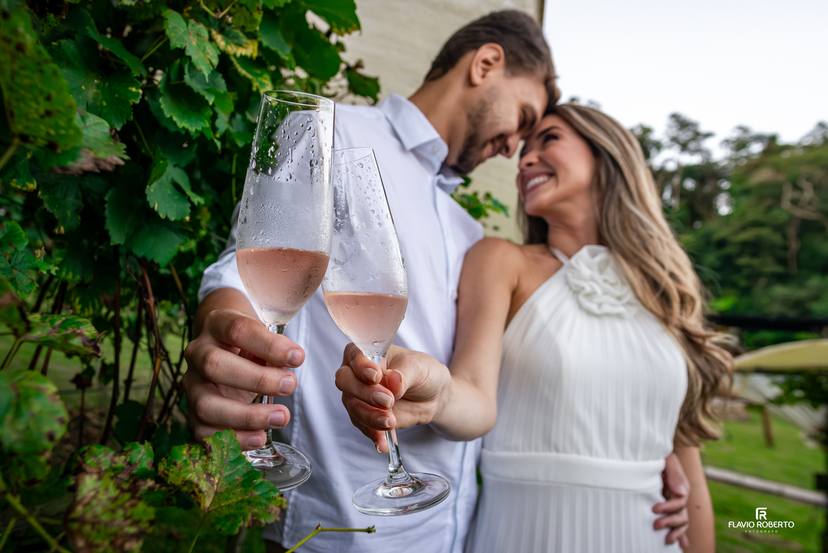 Casal brindando espumante durante ensaio pré wedding romântico em vinícola na Serra da Mantiqueira.