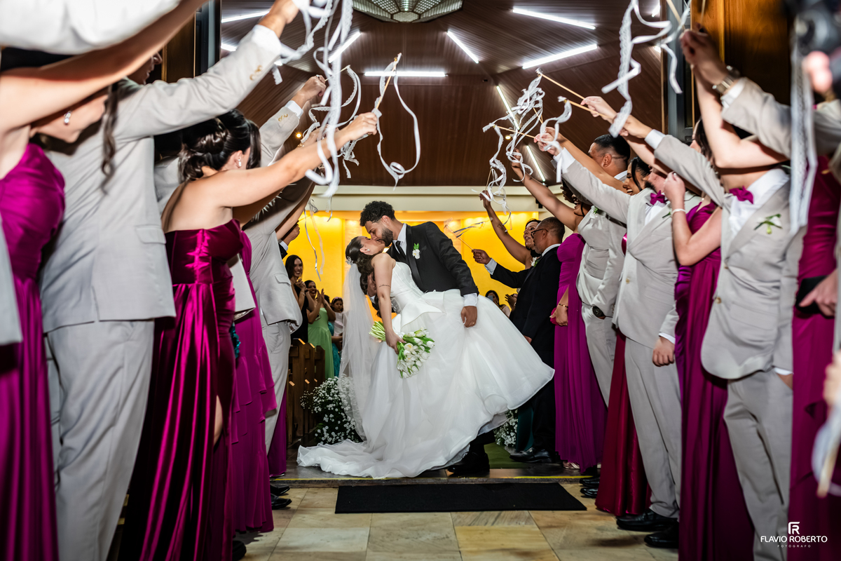 Beijo dos noivos na saída do Santuário São Benedito após a cerimônia de casamento.