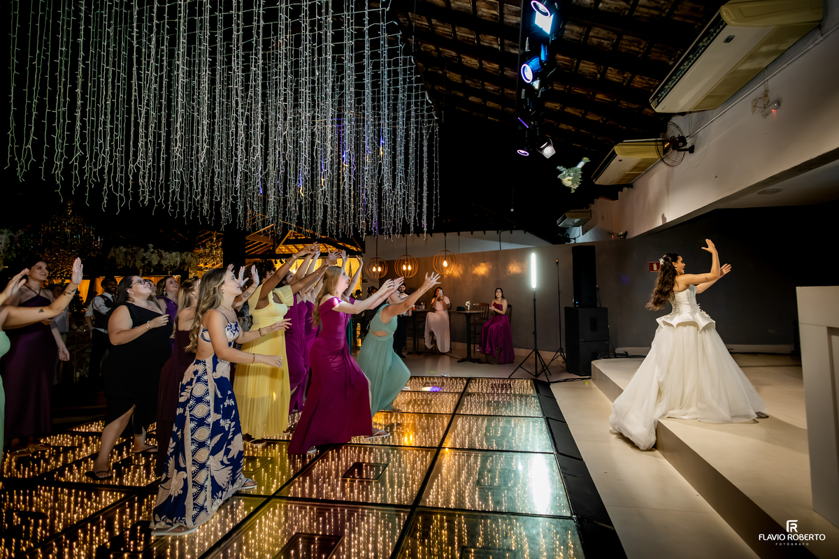 Momento do lançamento do buquê com amigas e madrinhas reunidas durante a festa de casamento no Sítio Tangaroa em Taubaté.