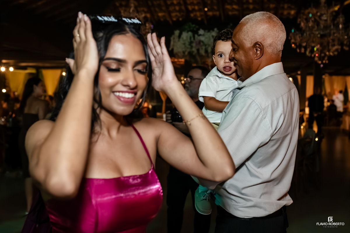 Convidada dançando e sorrindo enquanto familiares aproveitam a recepção de casamento no Sítio Tangaroa em Taubaté.