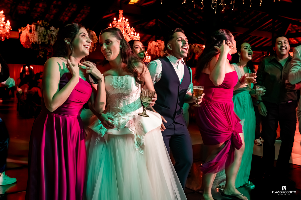 Amigos e familiares cantando juntos e celebrando momentos inesquecíveis durante a festa de casamento no Sítio Tangaroa em Taubaté.