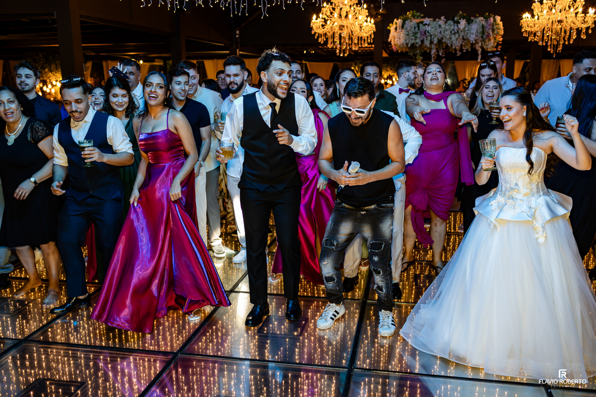 Convidados reunidos na pista de dança participando da animação da festa de casamento no Sítio Tangaroa em Taubaté.
