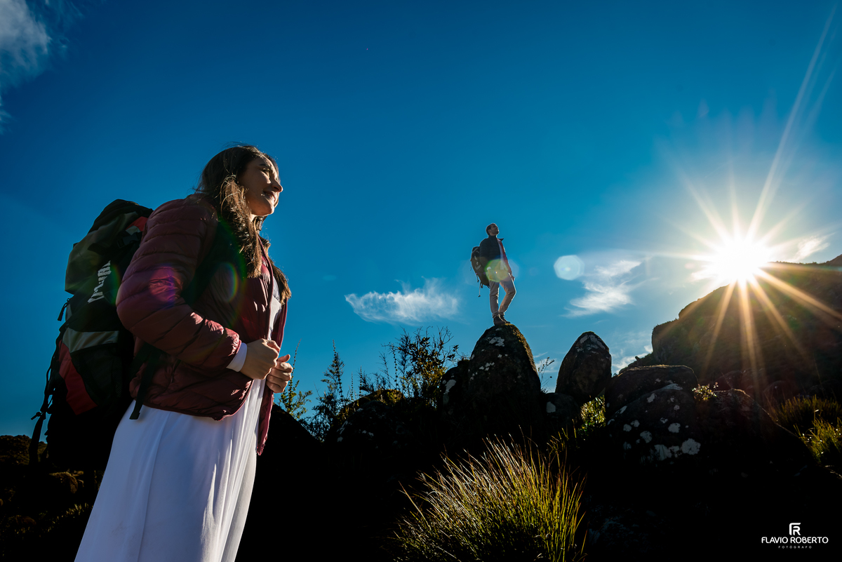 Casal em ensaio Pré Wedding nas montanhas do Parque Nacional do Itatiaia com o nascer do sol iluminando a paisagem.