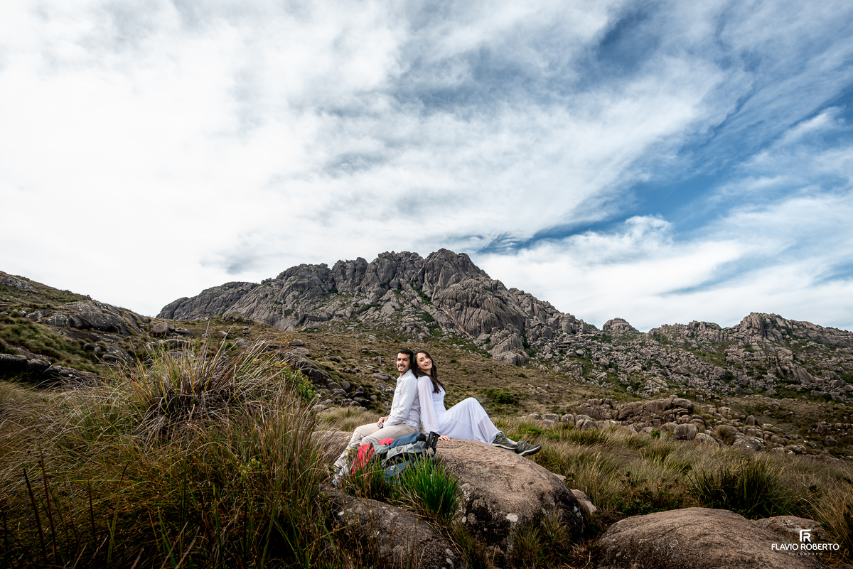 Casal sentado contemplando as montanhas do Parque Nacional do Itatiaia.