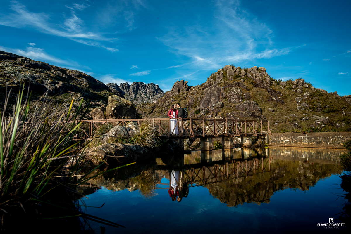 Jane e Vitor em ponte sobre lago com vista para o Pico das Agulhas Negras durante ensaio Pré Wedding.