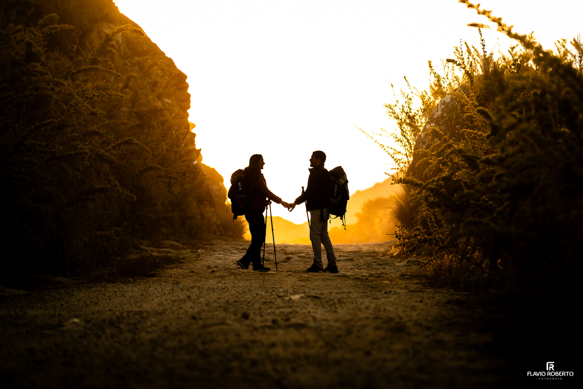 Casal de mãos dadas ao pôr do sol durante ensaio Pré Wedding nas montanhas de Itatiaia.