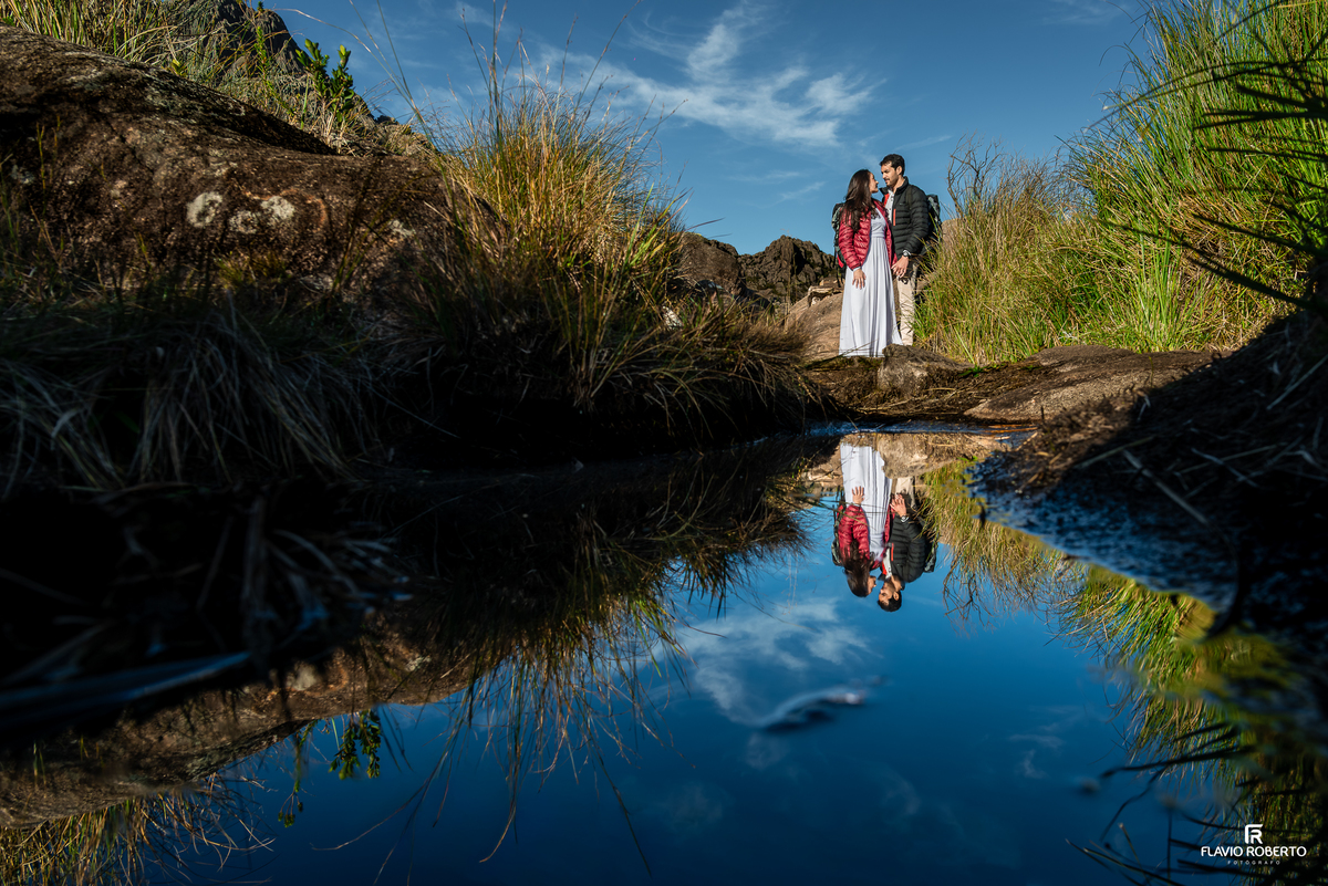 Jane e Vitor refletidos em poça d’água durante ensaio Pré Wedding no Pico das Agulhas Negras.