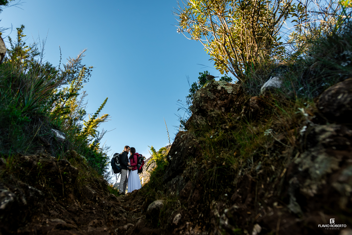 Casal abraçado em trilha cercada pela natureza do Parque Nacional do Itatiaia.