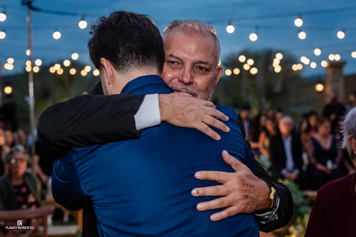 Noivo recebe abraço do pai após a cerimônia de casamento ao ar livre no Espaço Aloha.
