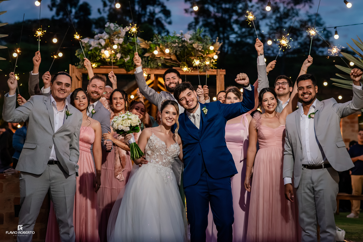 Noivos comemoram o casamento cercados por convidados e faiscas no Espaço Aloha em Cruzeiro.