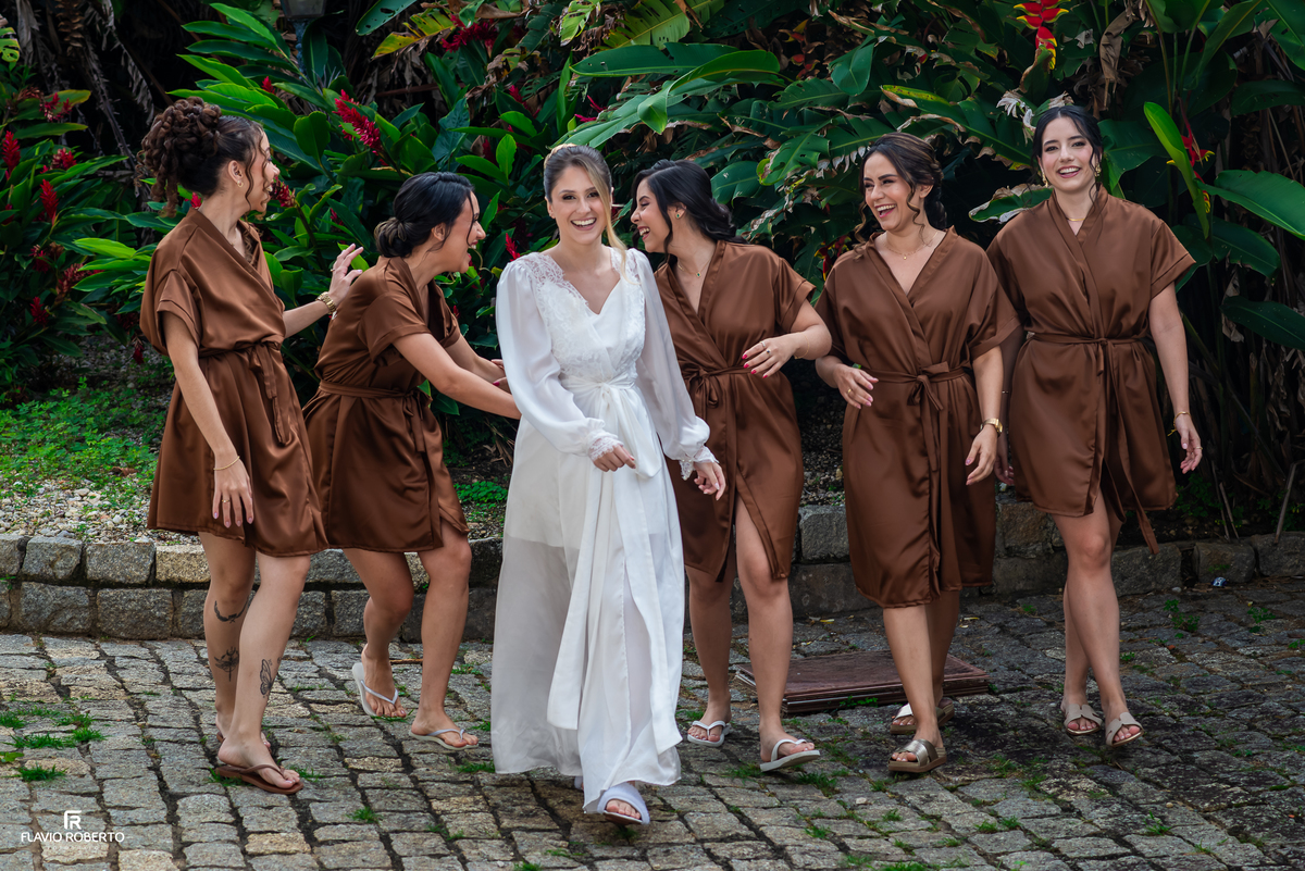 Noiva Júlia sorrindo ao lado das madrinhas durante o making of do casamento no Espaço Aloha em Cruzeiro/SP.